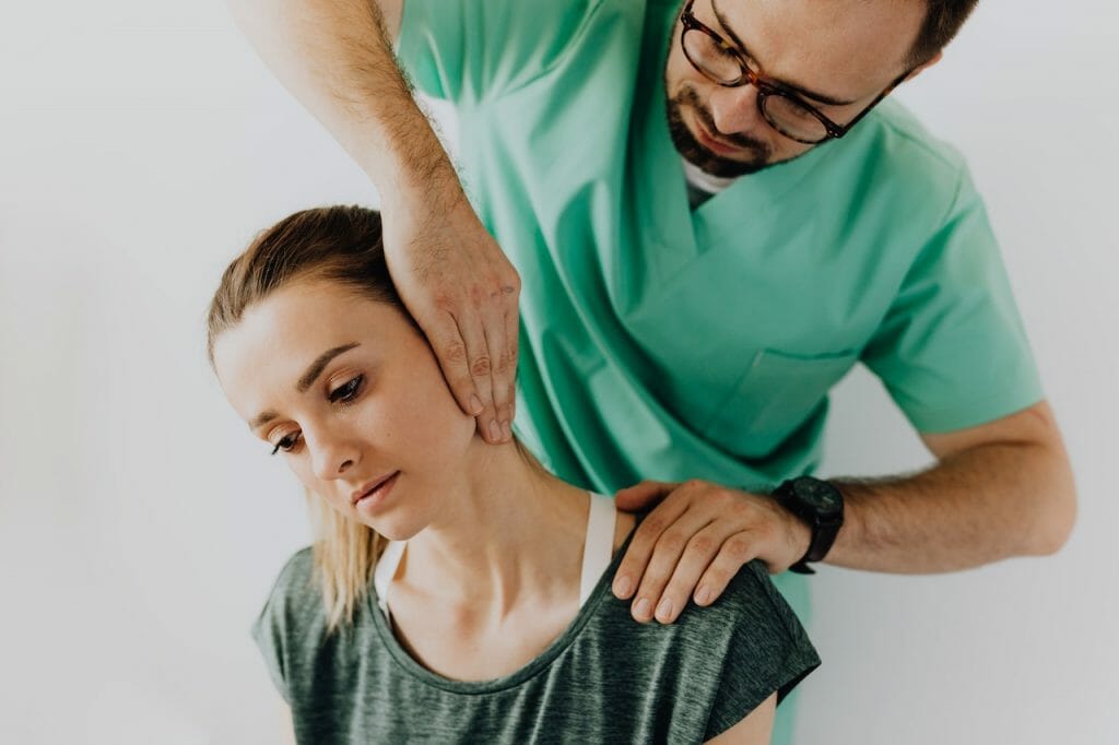 a doctor is addressing a patients pain points in her neck. small business websites can be like doctors for customers addressing pain points and needs.